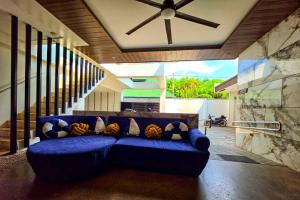 a blue couch in a living room with a ceiling at Lighthouse Point Hotel in Dumaguete