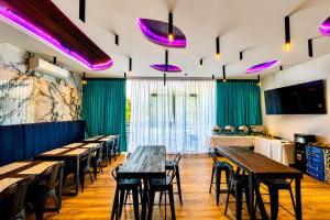 a row of tables and chairs in a restaurant with purple lights at Lighthouse Point Hotel in Dumaguete
