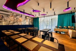 a restaurant with tables and chairs and purple lighting at Lighthouse Point Hotel in Dumaguete