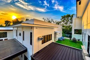 a house with a deck with a sunset in the background at Lighthouse Point Hotel in Dumaguete
