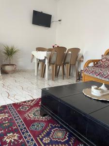 a living room with a couch and a table and chairs at Cozy Retreat in Bou Ficha