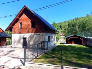 a large red and white barn with a garage at Oščadnica, Tadorka in Čadca
