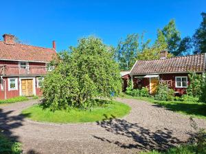 a house with a tree in the middle of a driveway at Stastugan in Grönhult