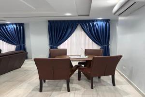 a dining room with blue curtains and a table and chairs at The Lodge at Seasons 52 in Oyibi