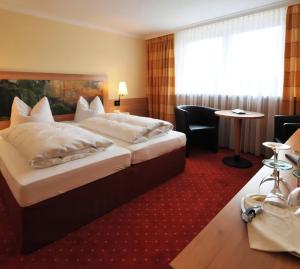 ein Hotelzimmer mit zwei Betten und einem roten Teppich in der Unterkunft Hotel Zum Kellermann in Grafenau