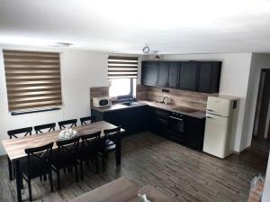 a kitchen with a table and a kitchen with a refrigerator at Oščadnica, Tadorka in Čadca