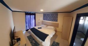 a small bedroom with a bed and a television at Citadel Boutique Hotel in Amman