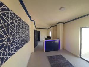 a room with a tv and a wall with a painting at Citadel Boutique Hotel in Amman