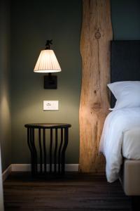 - une chambre avec un lit et une table avec une lampe dans l'établissement Locanda la Cross - Adults Only, à Garde