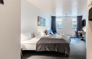 a bedroom with a white bed and a desk at Hotel Djurhuus in Tórshavn