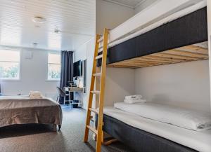 a bedroom with two bunk beds and a ladder at Hotel Djurhuus in Tórshavn