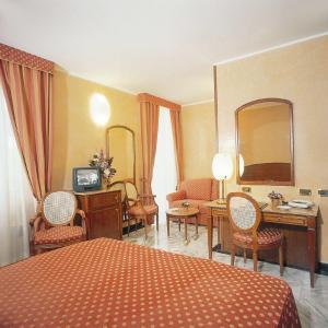 a hotel room with a bed and a desk and chairs at Hotel Ulivi in Arenzano
