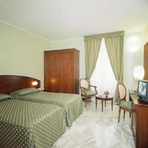 a bedroom with a bed and a television in it at Hotel Ulivi in Arenzano
