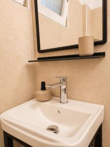 a white sink in a bathroom with a mirror at Tolo at sea - Nova in Tolo