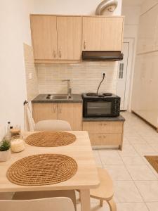 a kitchen with a table and chairs and a microwave at Tolo at sea - Nova in Tolo