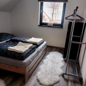 a bedroom with two beds and a ladder and a white rug at Oščadnica, Tadorka in Čadca