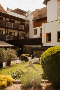 Eine Frau schwingt einen Baseballschläger in einem Garten in der Unterkunft Vulkanlandhotel Legenstein in Bad Gleichenberg
