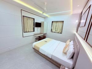 a bedroom with a bed and a sink in it at Hotel Le Glance Rooms & Dormitory in Mumbai