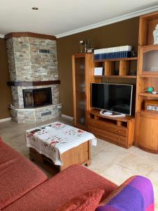 a living room with a tv and a fireplace at Chalet unifamiliar Foz-Nois in Barrosa