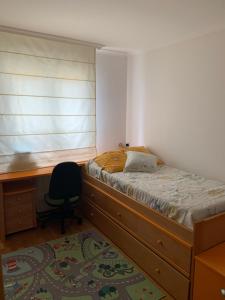 a bedroom with a bed and a desk and a chair at Chalet unifamiliar Foz-Nois in Barrosa