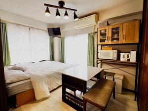 a bedroom with a bed and a desk in it at Miyabi Stay Tokyo in Kamatachō