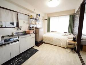a small kitchen with a bed and a sink at Miyabi Stay Tokyo in Kamatachō