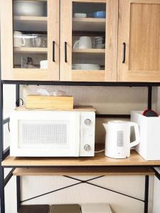 a counter with a microwave and other appliances on it at Miyabi Stay Tokyo in Kamatachō