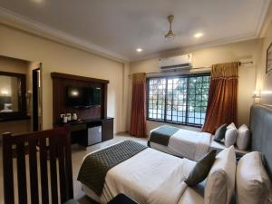 a hotel room with two beds and a television at HOTEL SAHANA CASTLE in Nāgercoil