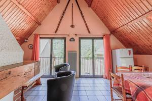 a dining room with a table and chairs and windows at Chalet à Aulus-Les-Bains in Aulus-les-Bains