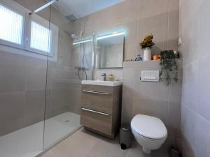 a bathroom with a toilet and a sink and a shower at Philoxenia in Bandol