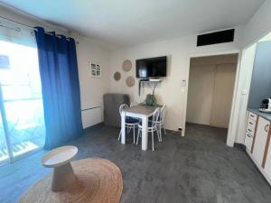 a room with a table and a kitchen with a table and chairs at Philoxenia in Bandol