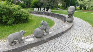 three statues of bears sitting on balls in a park at LECH Home APARTAMENT NA GÓRZE in Wisła
