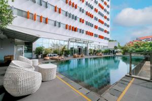 a swimming pool in front of a building at HARRIS Hotel Batam Center in Batam Center