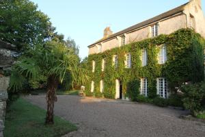 an ivycovered building with a palm tree in front of it at La Haute Flourie - bed and breakfast -chambres d'hôtes in Saint Malo
