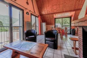 a living room with a table and chairs and a fireplace at Chalet à Aulus-Les-Bains in Aulus-les-Bains