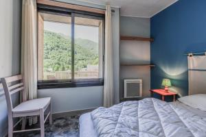 a bedroom with a bed and a large window at Chalet à Aulus-Les-Bains in Aulus-les-Bains