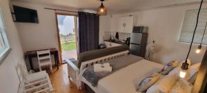 a bedroom with a bed and a kitchen with a window at Zonnevanger Guesthouse in Noorder-Paarl
