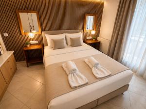 a bedroom with a large bed with towels on it at Atlantis Hotel in Agios Nikolaos