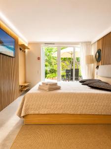 a bedroom with a large bed with a large window at Sodyba prie jūros in Palanga