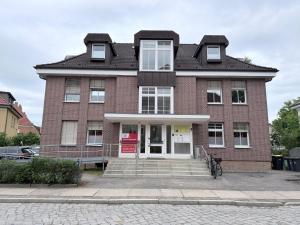 a red brick building with a white door at Gemütliche Ferienwohung in Neubrandenburg
