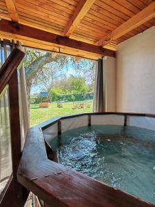 a hot tub in a house with a large window at Bakonyi Vénkörte Vendégház in Bakonypéterd