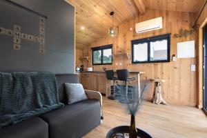 a living room with a couch and a kitchen at Ma cabane Océan in Le Verdon-sur-Mer