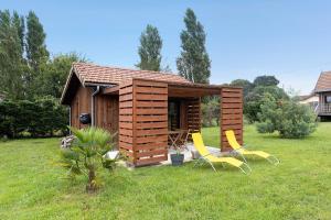 a small cabin with two yellow chairs in the grass at Ma cabane Océan in Le Verdon-sur-Mer