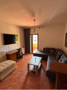 a living room with a couch and a table at Garni Hotel Meduza in Rafailovici