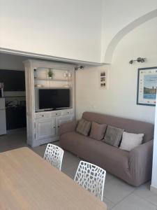 a living room with a couch and a tv at Golfe de Saint Tropez Terrasses de Sylvabelle Gigaro in La Croix-Valmer