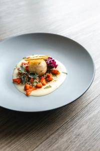 ein Teller mit einer Schüssel Essen auf einem Tisch in der Unterkunft Vulkanlandhotel Legenstein in Bad Gleichenberg + 78 Fotos