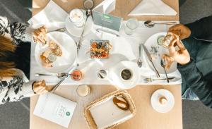 zwei Personen essen an einem Tisch mit Tellern voller Essen in der Unterkunft Vulkanlandhotel Legenstein in Bad Gleichenberg