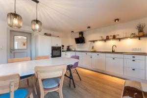 a kitchen with white cabinets and a table and chairs at Ferienhaus Rabenbrunn in Arnstorf