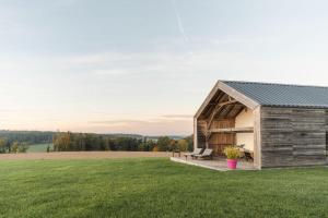 a barn with a bench on a grass field at Ferienhaus Rabenbrunn in Arnstorf