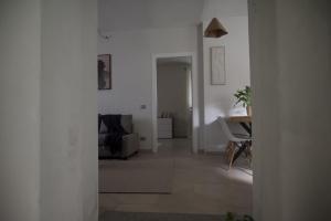 a living room with white walls and a table at Langhem Suites Luxury Apartments in Castiglione Falletto +34 photos